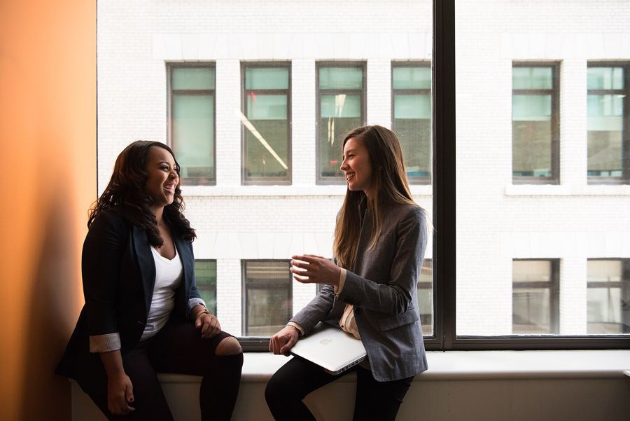 Two colleagues talking by an office window