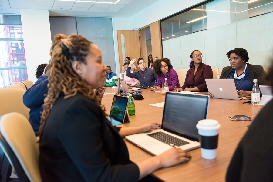 A team meeting around a table with laptops